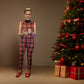 Holiday spirit exudes from woman in plaid jumpsuit by Christmas tree