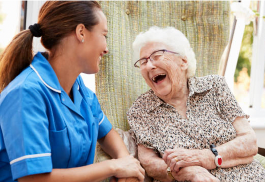 Nurse holding hand of a sweet grandma who is laughing