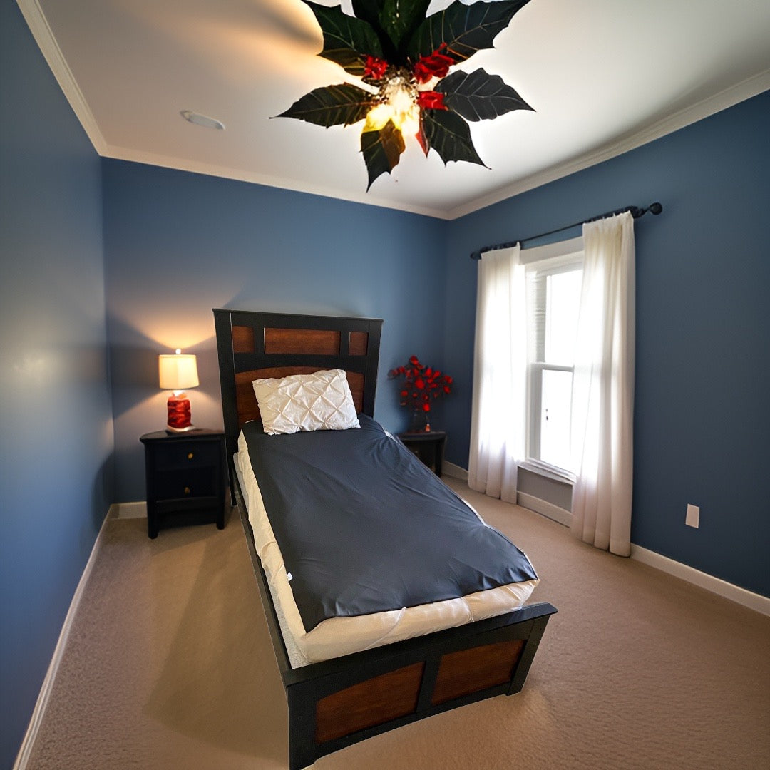 A blue-walled bedroom with a bed, Christmas tree, and waterproof bed protector sheet