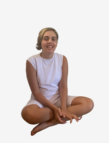 Woman in Anti Strip Bodysuit rests on floor, dressed in serene white